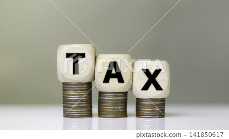 Tax increase concept. tax icon on coins. increasing taxes, Pay online income tax. income tax system icon around on wood floor background. Tax increase concept. tax icon on coins. increasing taxes, Pay online income tax. income tax system icon around on wood floor background. 141850617