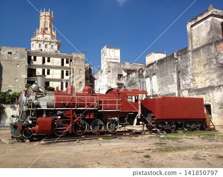 Cuba Tourism: A retro red steam locomotive stands amidst the streets of Havana. Cuba Tourism: A retro red steam locomotive stands amidst the streets of Havana. 141850797
