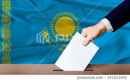 Kazakhstan Parliamentary vote. Hand placing a ballot in ballot box with the Kazakh flag in the background Kazakhstan Parliamentary vote. Hand placing a ballot in ballot box with the Kazakh flag in the background 141851041