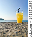 Cold orange juice placed on the beach 141851984