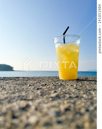 Cold orange juice placed on the beach Cold orange juice placed on the beach 141851984