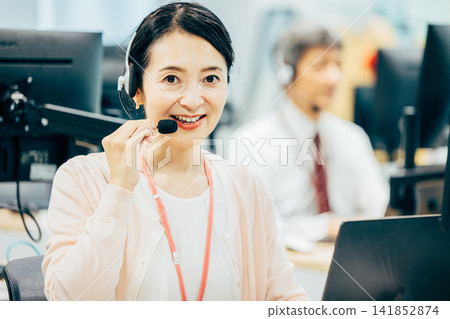 Female operator working in a call center Female operator working in a call center 141852874