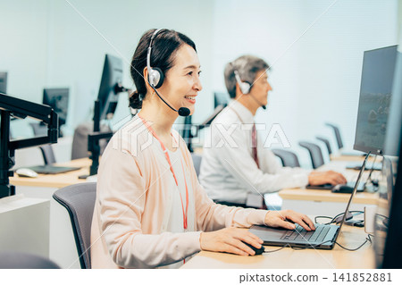 Female operator working in a call center Female operator working in a call center 141852881