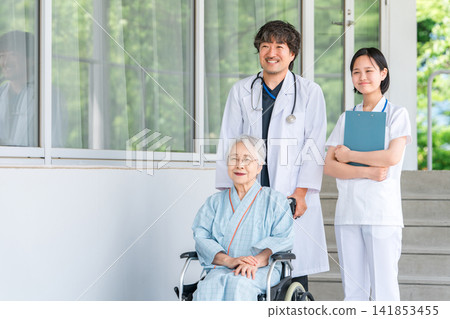 坐輪椅的老人以及醫院和護理機構的醫生和護士 坐輪椅的老人以及醫院和護理機構的醫生和護士 141853455