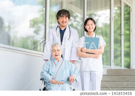 坐輪椅的老人以及醫院和護理機構的醫生和護士 坐輪椅的老人以及醫院和護理機構的醫生和護士 141853458
