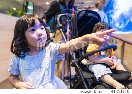 A Japanese brother and sister look up at the aquarium tanks. A Japanese brother and sister look up at the aquarium tanks. 141853918