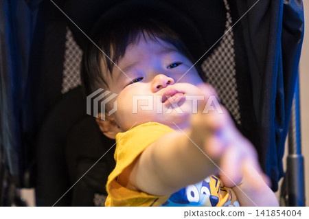 A Japanese baby boy in a stroller looking at the fish tanks at an aquarium. A Japanese baby boy in a stroller looking at the fish tanks at an aquarium. 141854004