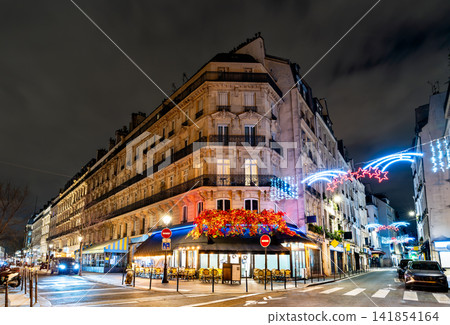 Traditional Parisian corner cafe decorated with Christmas lights at night in Paris Traditional Parisian corner cafe decorated with Christmas lights at night in Paris 141854164
