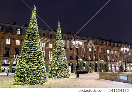 Illuminated Christmas trees on snowy Place Vendome at night in Paris Illuminated Christmas trees on snowy Place Vendome at night in Paris 141854183