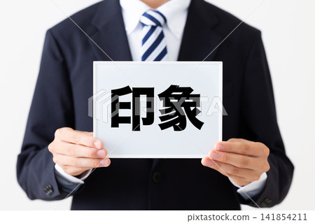 A young businessman in a business suit holding an impressive whiteboard. A young businessman in a business suit holding an impressive whiteboard. 141854211