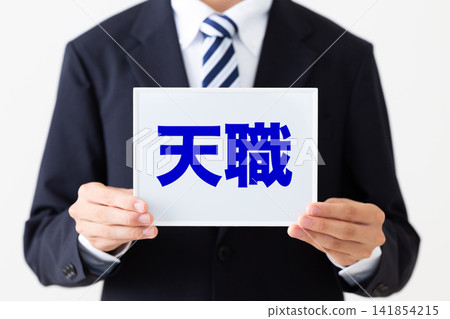 A young businessman in a business suit holding a whiteboard listing his ideal job. A young businessman in a business suit holding a whiteboard listing his ideal job. 141854215