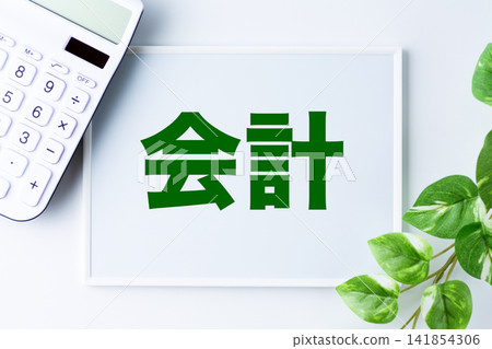 A whiteboard with the word "accounting" and a white calculator A whiteboard with the word "accounting" and a white calculator 141854306