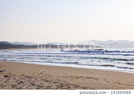 The sea at sunset and surfers The sea at sunset and surfers 141854369