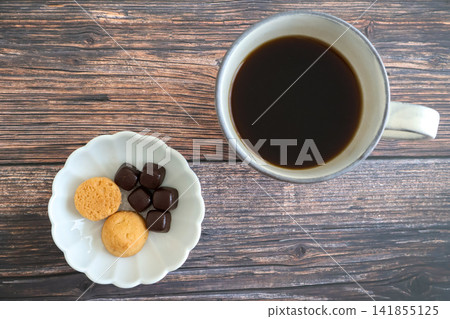 Hot coffee, cookies, and chocolate placed on a wooden table Hot coffee, cookies, and chocolate placed on a wooden table 141855125