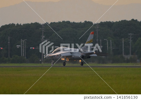 A Japan Air Self-Defense Force T-4 trainer aircraft landing at dusk. A Japan Air Self-Defense Force T-4 trainer aircraft landing at dusk. 141856130