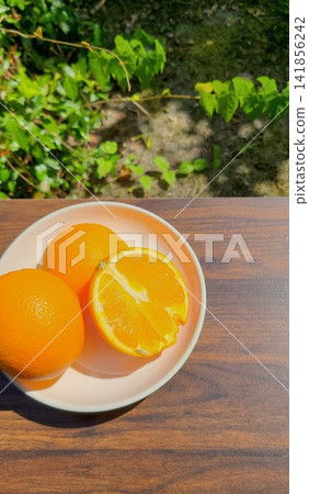 Oranges on a plate and oranges cut in half 141856242