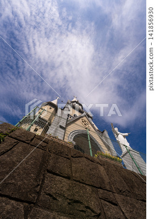 Looking up at the Catholic Miura-cho Church in Sasebo under a blue sky and wispy clouds. Looking up at the Catholic Miura-cho Church in Sasebo under a blue sky and wispy clouds. 141856930