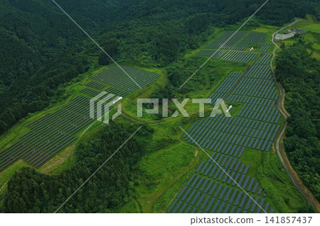 一張空拍照片,展現了群馬縣高崎市丘陵地帶上綿延的巨型太陽能發電廠。 一張空拍照片,展現了群馬縣高崎市丘陵地帶上綿延的巨型太陽能發電廠。 141857437