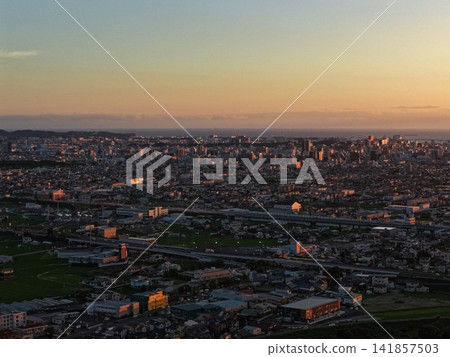 An aerial photograph of the sunset overlooking Wakayama city and the coastline. An aerial photograph of the sunset overlooking Wakayama city and the coastline. 141857503