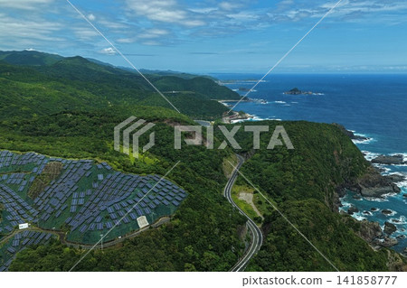An aerial photograph capturing solar panels installed on a cliff in Susami Town, Wakayama Prefecture, and the coastline. An aerial photograph capturing solar panels installed on a cliff in Susami Town, Wakayama Prefecture, and the coastline. 141858777
