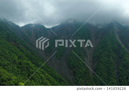 An aerial photograph capturing the steep mountain slopes and eroded valleys of Otani-kuzure in Shizuoka Prefecture. An aerial photograph capturing the steep mountain slopes and eroded valleys of Otani-kuzure in Shizuoka Prefecture. 141859226