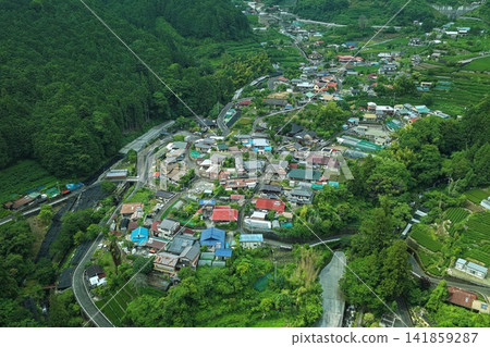 一張空拍照片,展現了靜岡縣靜岡市山區的一片房屋和茶園。 一張空拍照片,展現了靜岡縣靜岡市山區的一片房屋和茶園。 141859287