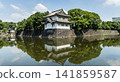 The moat's calm surface reflected the old Sakurada Tatsumi Yagura and stone walls, one of the Three Surviving Watchtowers of Edo Castle, in Tokyo Imperial Palace, Chiyoda, Japan. 141859587