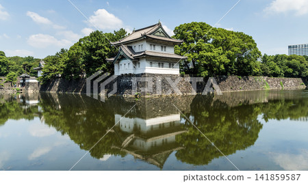 The moat's calm surface reflected the old Sakurada Tatsumi Yagura and stone walls, one of the Three Surviving Watchtowers of Edo Castle, in Tokyo Imperial Palace, Chiyoda, Japan. The moat's calm surface reflected the old Sakurada Tatsumi Yagura and stone walls, one of the Three Surviving Watchtowers of Edo Castle, in Tokyo Imperial Palace, Chiyoda, Japan. 141859587