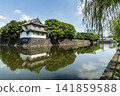 The moat's calm surface reflected the old Sakurada Tatsumi Yagura and stone walls, one of the Three Surviving Watchtowers of Edo Castle, in Tokyo Imperial Palace, Chiyoda, Japan. 141859588