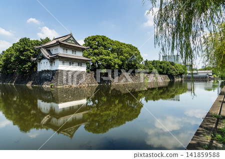 The moat's calm surface reflected the old Sakurada Tatsumi Yagura and stone walls, one of the Three Surviving Watchtowers of Edo Castle, in Tokyo Imperial Palace, Chiyoda, Japan. The moat's calm surface reflected the old Sakurada Tatsumi Yagura and stone walls, one of the Three Surviving Watchtowers of Edo Castle, in Tokyo Imperial Palace, Chiyoda, Japan. 141859588