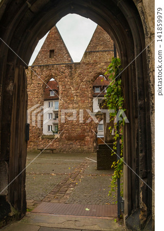 Scenic view through the stone archway into the interior of the destroyed roofless Aegidienkirche church in Hannover, Germany 141859979