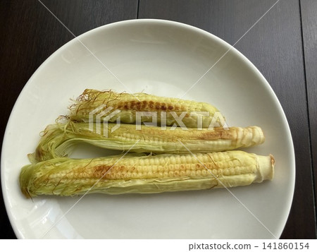 Grilled baby corn on a white plate Grilled baby corn on a white plate 141860154
