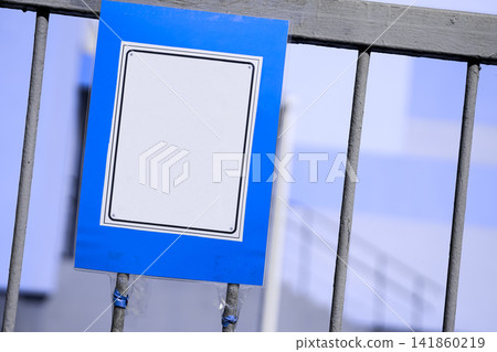 Blue and white sign on gray metal fence Blue and white sign on gray metal fence 141860219