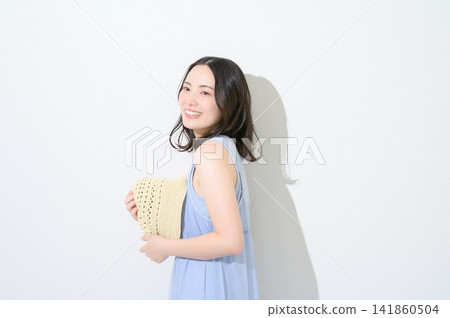 一位日本女性手持帽子,在白色背景前,展現出美麗的形象。 一位日本女性手持帽子,在白色背景前,展現出美麗的形象。 141860504