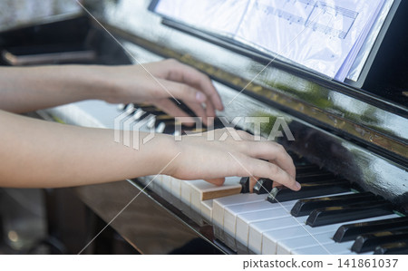 Close Up Side View of Hands Playing Piano Outdoors Close Up Side View of Hands Playing Piano Outdoors 141861037