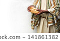Man's hans holding fresh bread 141861382