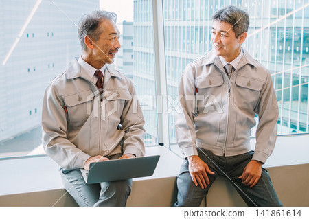 Senior men in work clothes having a meeting Senior men in work clothes having a meeting 141861614