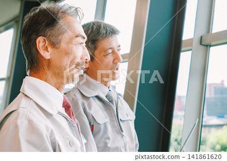 Senior men in work clothes having a meeting Senior men in work clothes having a meeting 141861620