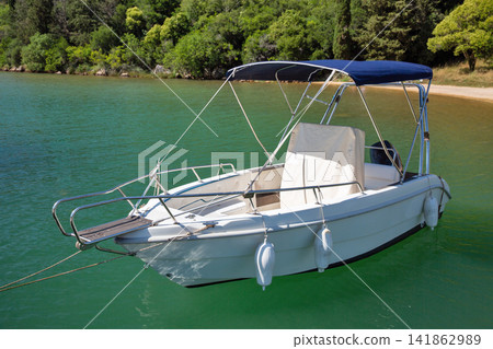 Modern motorboat with red canopy moored in Lim Fjord, Croatia. Modern motorboat with red canopy moored in Lim Fjord, Croatia. 141862989