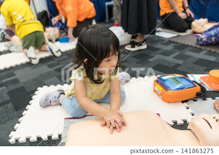 一名日本小女孩在緊急救生體驗活動中觸摸了AED（自動體外心臟去顫器）。 141863275