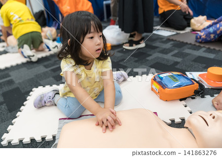 一名日本小女孩在緊急救生體驗活動中觸摸了AED（自動體外心臟去顫器）。 141863276