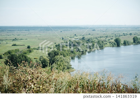 Panoramic summer landscape of the Kama River, with meadows and green trees on the bank. Panoramic summer landscape of the Kama River, with meadows and green trees on the bank. 141863319