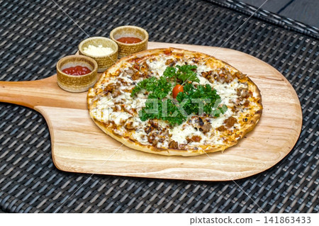 Gourmet Meat Pizza with Mozzarella Parsley and Dipping Sauces on Wooden Paddle Board Gourmet Meat Pizza with Mozzarella Parsley and Dipping Sauces on Wooden Paddle Board 141863433