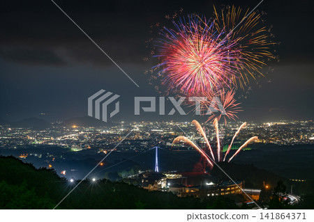 The fireworks illuminating the night sky above Mishima Skywalk and the spectacular view of the illuminated suspension bridge. The fireworks illuminating the night sky above Mishima Skywalk and the spectacular view of the illuminated suspension bridge. 141864371