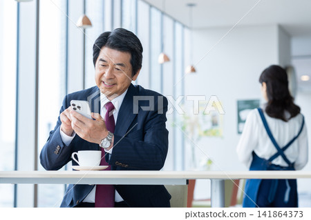一位中年商務人士在咖啡館放鬆休息。攝影協助:電波學園教育基金會、東京電子大學 一位中年商務人士在咖啡館放鬆休息。攝影協助:電波學園教育基金會、東京電子大學 141864373