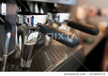 Espresso Extraction From Portafilter on Professional Coffee Machine in Modern Cafe Environment Espresso Extraction From Portafilter on Professional Coffee Machine in Modern Cafe Environment 141864552