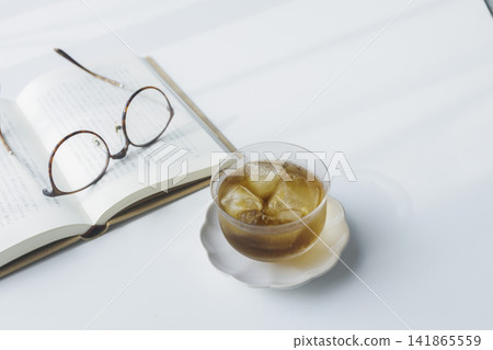 Cold barley tea, a book, and glasses; summer reading time and copy space. Cold barley tea, a book, and glasses; summer reading time and copy space. 141865559
