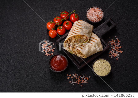 Grilled chicken shawarma or doner with tomatoes, cucumber, and sauces, takeout food Grilled chicken shawarma or doner with tomatoes, cucumber, and sauces, takeout food 141866255