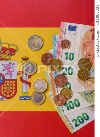 Spain, Spanish euro cash and cent coins against the background of the flag. Euro cash Spain, Spanish euro cash and cent coins against the background of the flag. Euro cash 141866322