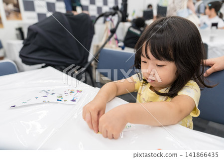 一位日本小女孩在工作坊專心製作貼紙工藝品。 141866435